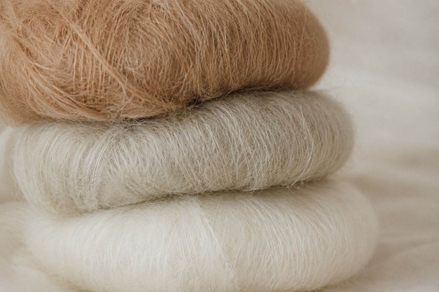 Natural fiber yarn skeins in camel, grey and ivory